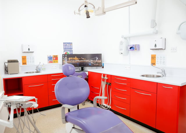 A Jamil Dental treatment room with worktop, sink and branded wall panel